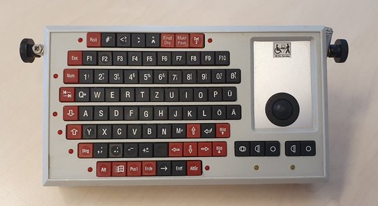 Bild zeigt eine miniaturisierte Tastatur mit roten und schwarzen Tasten