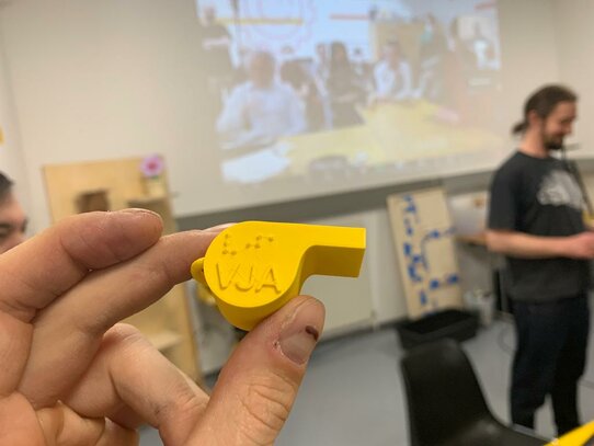 gelbe Pfeife 3D gedruckt und mit Brailleschrift beschriftet