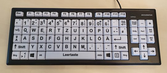 Bild zeigt eine schwarze Tastatur mit großen weißen Tasten