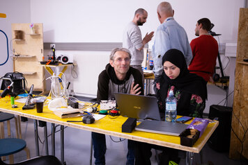 Chris und eine Studentin sitzen und arbeiten an diesem Projekt