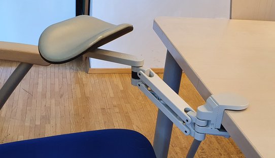 Bild zeigt eine Unterarmstütze mit Polsterung an einer Tischkante montiert